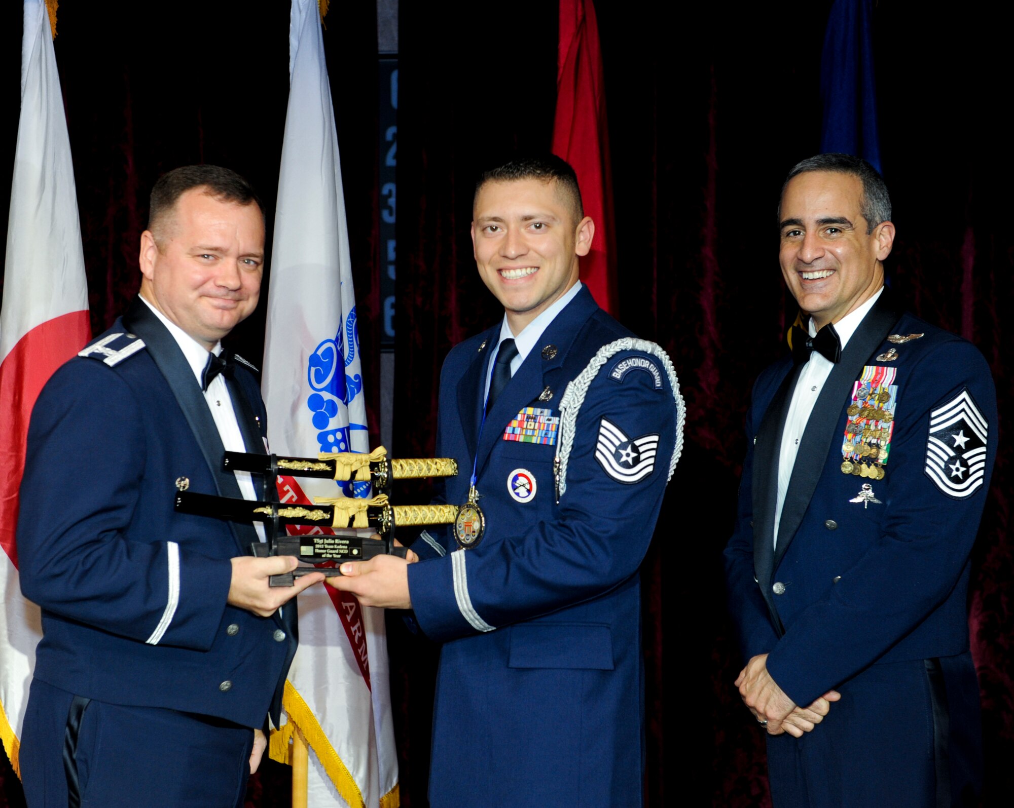 U.S. Air Force Tech. Sgt. Julio Rivera, 18th Civil Engineer Squadron, receives an award from Col. Brian McDaniel, 18th Wing vice commander, during the annual awards ceremony at the Rocker NCO Club on Kadena Air Base, Japan, Feb. 9, 2013. Rivera was recognized as the Kadena Honor Guard NCO of the Year for 2012. (U.S. Air Force photo/Airman 1st Class Justin Veazie)