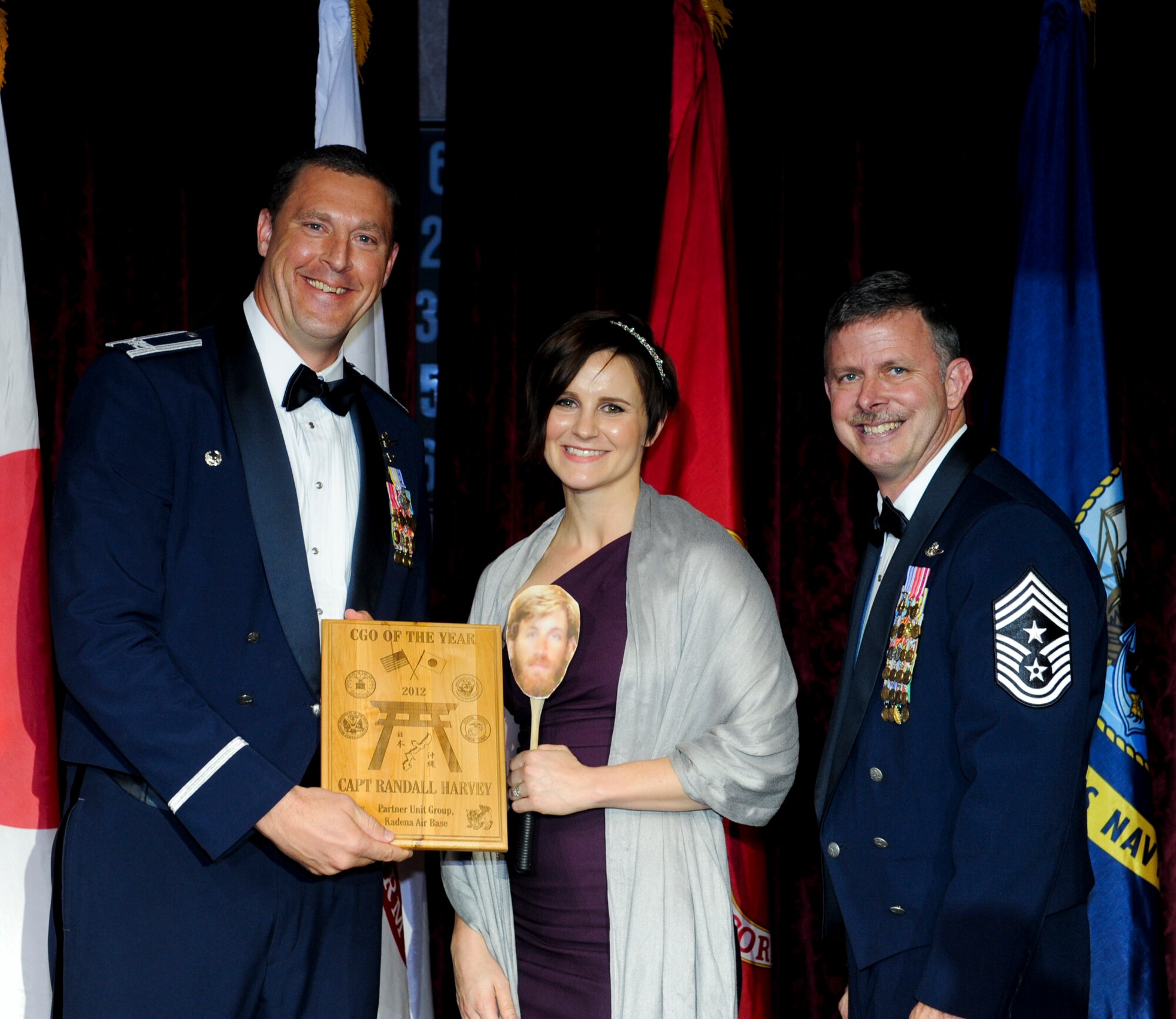 Susan Harvey, spouse of U.S. Air Force Capt. Randall Harvey, 353rd Special Operations Group, accepts an award on behalf of her husband from Col. Brad Sullivan, 353rd SOG commander, during the annual awards ceremony at the Rocker NCO Club on Kadena Air Base, Japan, Feb. 9, 2013. Harvey was recognized as the Partner Unit Group Company Grade Officer of the Year for 2012. (U.S. Air Force photo/Airman 1st Class Justin Veazie)