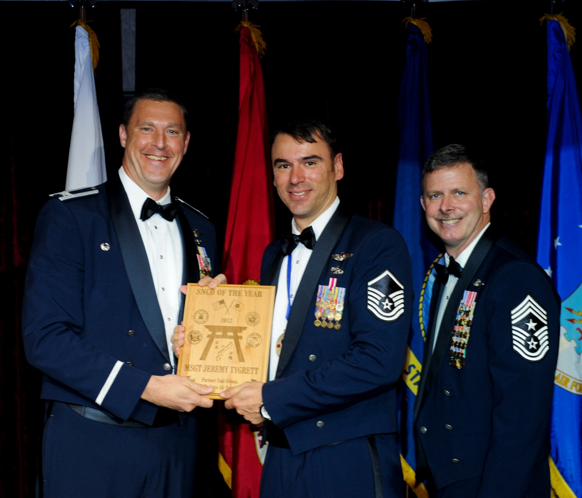 U.S. Air Force Master Sgt. Jeremy Tygrett, 353rd Special Operations Group, receives an award from Col. Brad Sullivan, 353rd SOG commander, during the annual awards ceremony at the Rocker NCO Club on Kadena Air Base, Japan, Feb. 9, 2013. Tygrett was recognized as the Partner Unit Group Senior NCO of the Year for 2012. (U.S. Air Force photo/Airman 1st Class Justin Veazie)