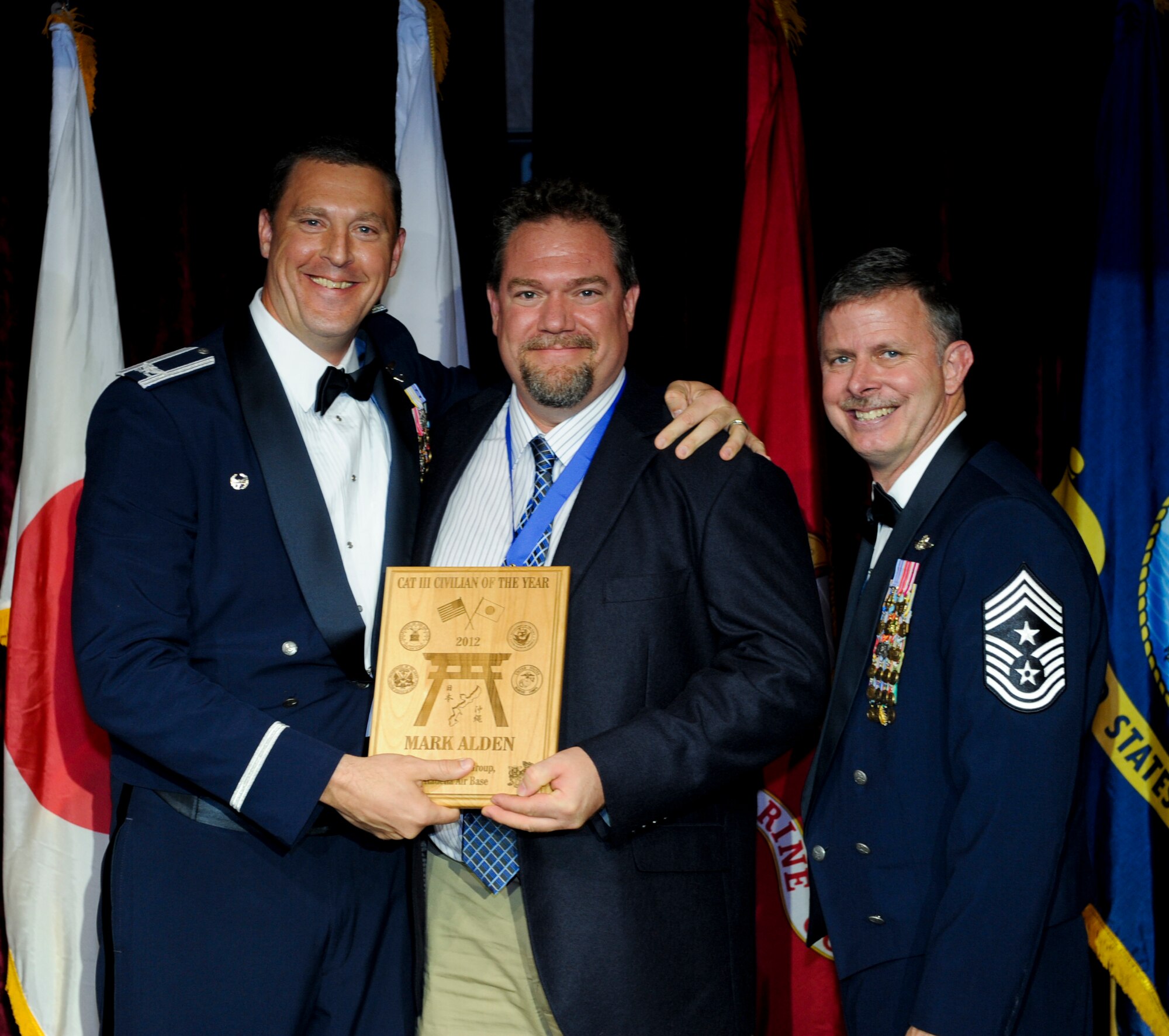 Mark Alden, 353rd Special Operations Group, receives an award from U.S. Air Force Col. Brad Sullivan, 353rd SOG commander, during the annual awards ceremony at the Rocker NCO Club on Kadena Air Base, Japan, Feb. 9, 2013. Alden was recognized as the Partner Unit Group Category III Civilian of the Year for 2012. (U.S. Air Force photo/Airman 1st Class Justin Veazie)