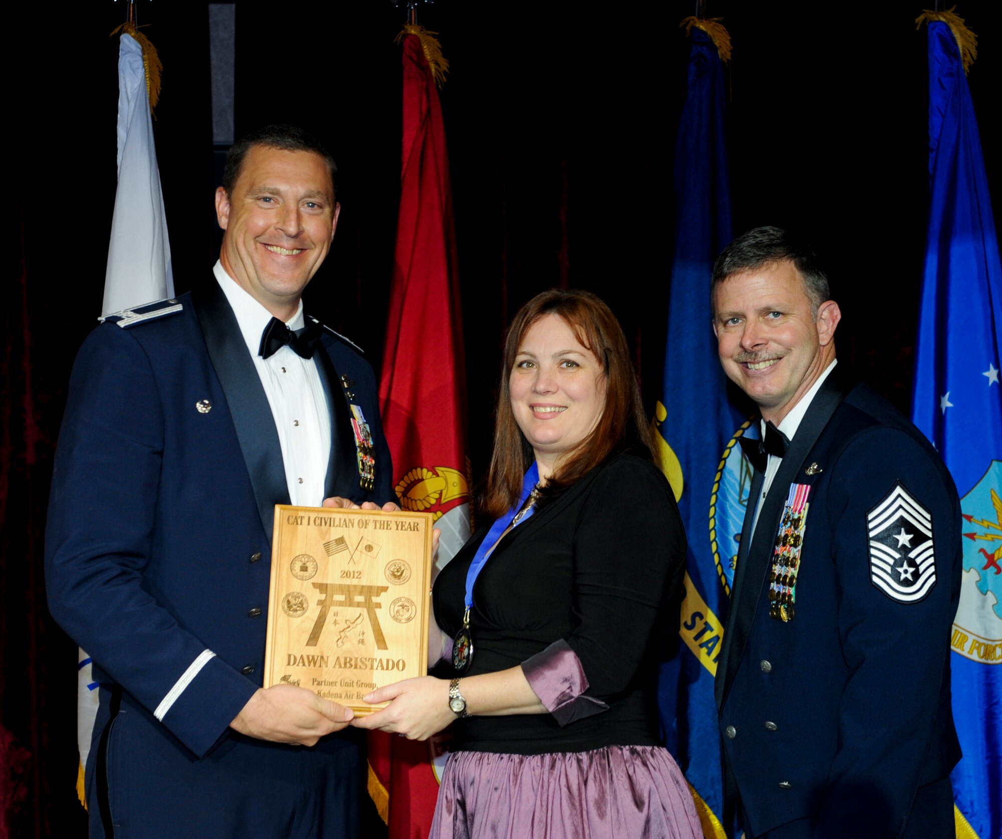 Dawn Abistado, 353rd Special Operations Group, receives an award from U.S. Air Force Col. Brad Sullivan, 353rd SOG commander, during the annual awards ceremony at the Rocker NCO Club on Kadena Air Base, Japan, Feb. 9, 2013. Harvey was recognized as the Partner Unit Group Category I Civilian of the Year for 2012. (U.S. Air Force photo/Airman 1st Class Justin Veazie)