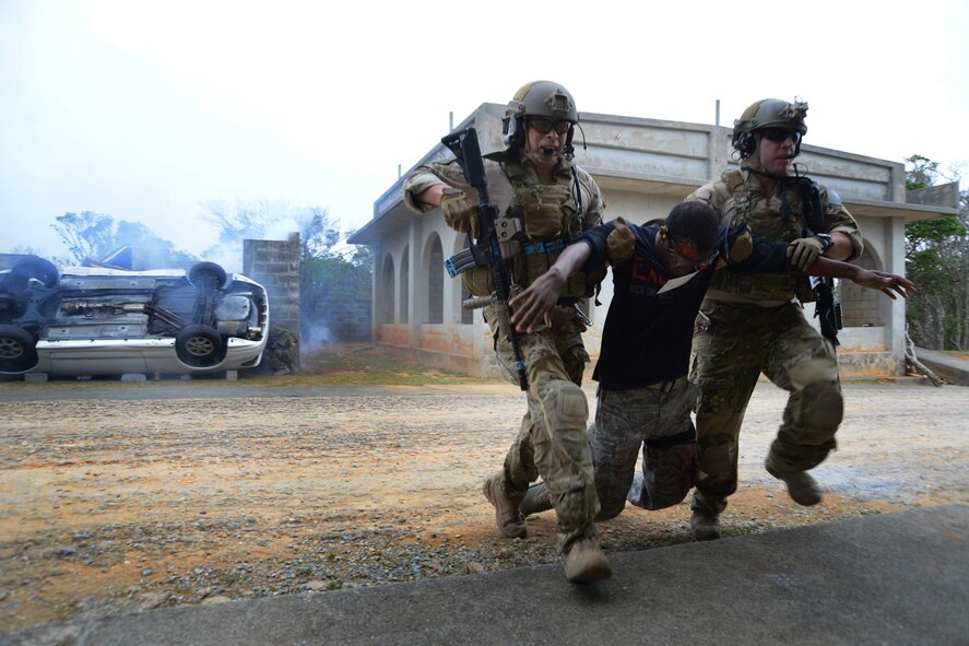 U.S. Air Force pararescuemen Staff Sgts. Elmer Quijada and Staff Sgt. Jacob Schaumberg from the 31st Rescue Squadron race across the street to safety, carrying Airman 1st Class Leonard Hutchenson, 18th Maintenance Squadron knowledge operator, from simulated aircraft wreckage during a war week exercise at Marine Corps Camp Hansen's Combat Town, Japan, Feb. 7, 2013. Quijada is a traditional guardsman from the 123rd Special Tactics Squadron, Kentucky Air National Guard. He is here training with the team that he will be deploying. (U.S. Air Force Photo/Tech. Sgt. Jocelyn L. Rich-Pendracki)