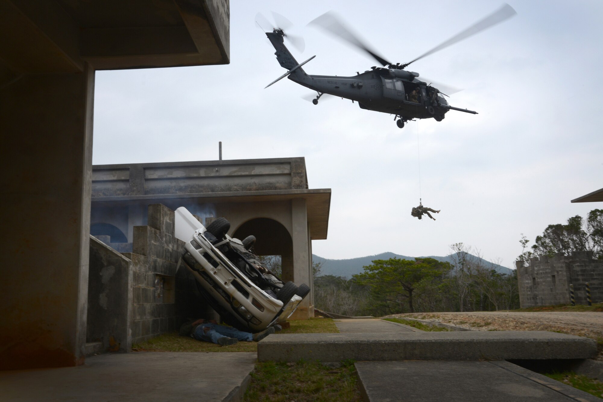 A U.S. Air Force HH-60G Pave Hawk helicopter hovers as members of the 31st and 33rd Rescue Squadrons run through a combat rescue scenario during a war week exercise at Marine Corps Camp Hansen's Combat Town, Japan, Feb. 7, 2013. War week was a three-day battery of combat and rescue scenarios to train members of the 31st and 33rd Rescue squadrons before an upcoming deployment. (U.S. Air Force Photo/Tech. Sgt. Jocelyn L. Rich-Pendracki)