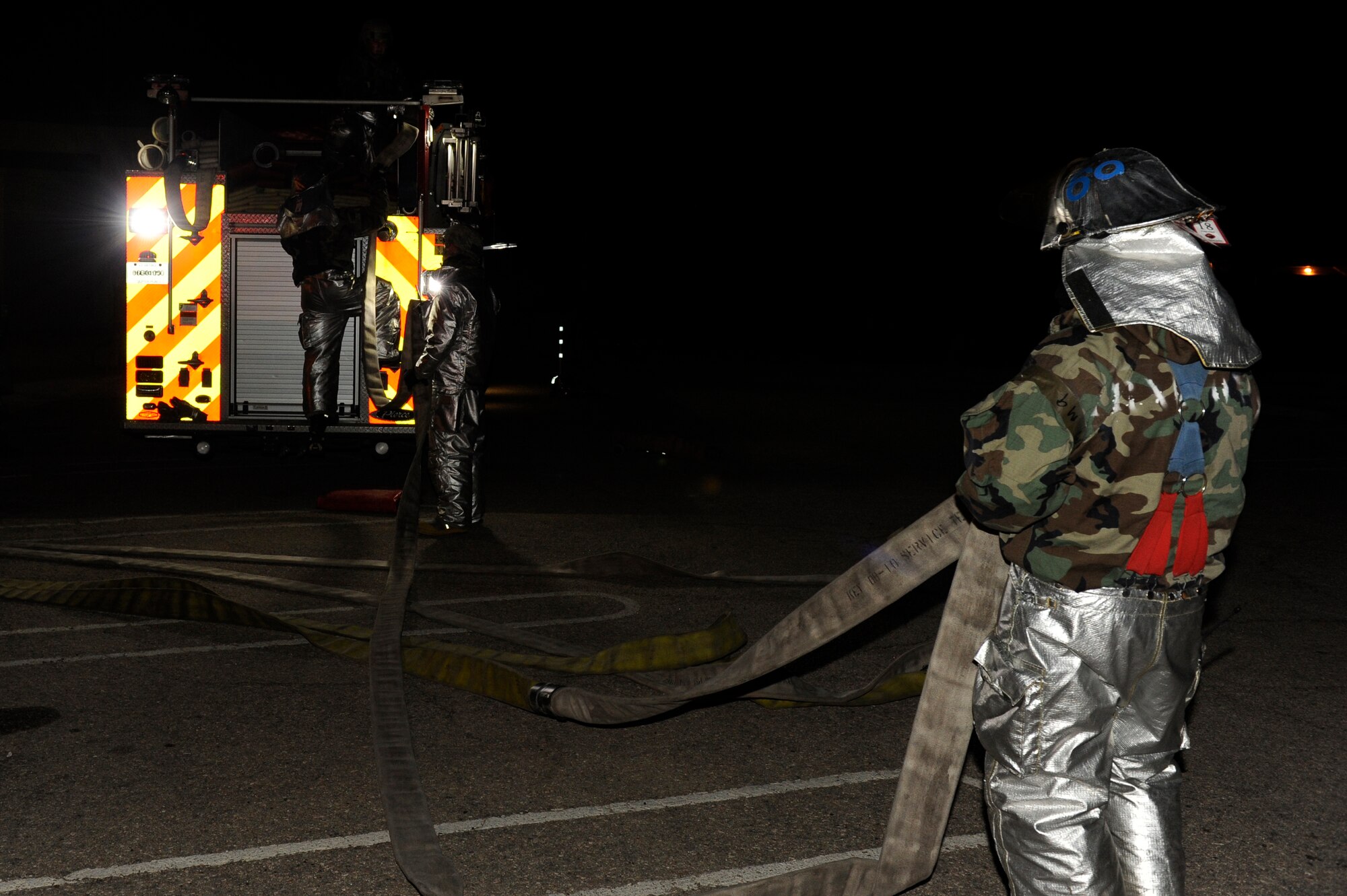 KUNSAN AIR BASE, Republic of Korea --  Firefighter from the 8th Civil Engineer Squadron straightens a hose after responding to a simulated fire at the emergency operations center during the early morning hours of  exercise Beverly Bulldog 13-2 at Kunsan Air Base, Republic of Korea, Feb. 13, 2013. The scenario allowed firefighters to practice their skills at fighting fires and searching for injured members (U.S. Air Force photo by Senior Airman Marcus Morris/Released) 