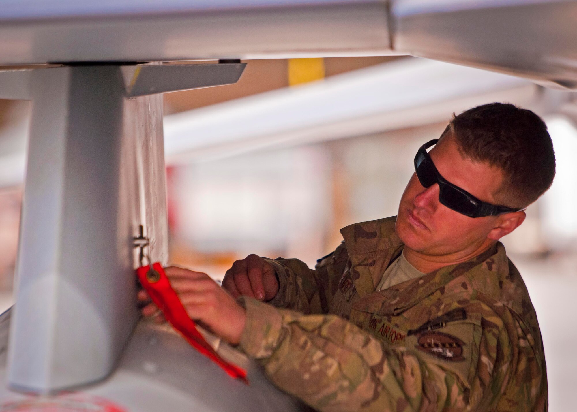 KANDAHAR AIRFIELD, Afghanistan -- Senior Airman Matthew Furey, 451st Expeditionary Aircraft Maintenance Squadron weapons load crew member, inspects F-16 Fighting Falcon’s wing fuel tank during a weapons load competition here Feb. 11. Furey and two other Airmen competed as a weapons load crew and completed a four-phase evaluation. Their overall score will be put up against other scores of weapons load crews from their home station, Shaw Air Force Base, S.C.  (U.S. Air Force photo/Senior Airman Scott Saldukas)