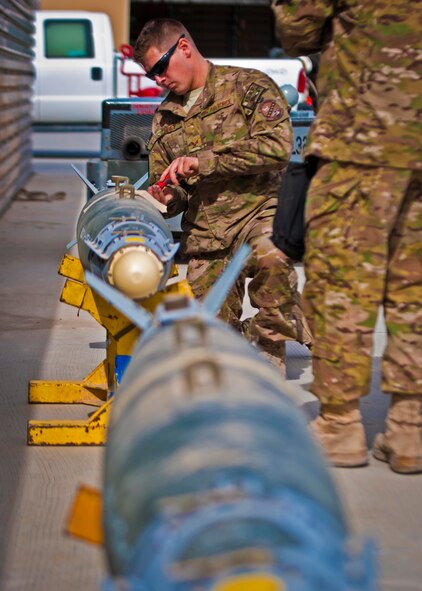 KANDAHAR AIRFIELD, Afghanistan -- Senior Airman Matthew Furey, 451st Expeditionary Aircraft Maintenance Squadron weapons load crew member, prepares a GBU-38 bomb before it is loaded to an F-16 Fighting Falcon during a weapons load competition here Feb. 11. Furey and two other Airmen competed as a weapons load crew and completed a four-phase evaluation. Their overall score will be put up against other scores of weapons load crews from their home station, Shaw Air Force Base, S.C.   (U.S. Air Force photo/Senior Airman Scott Saldukas)