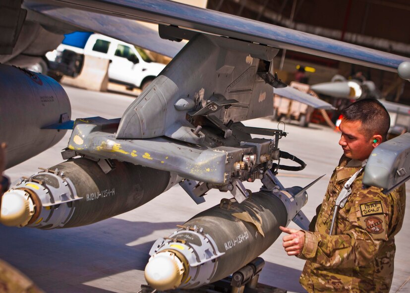 KANDAHAR AIRFIELD, Afghanistan -- Staff Sgt. William Bernhardt, 451st Expeditionary Aircraft Maintenance Squadron weapons load team chief, inspects a GBU-38 bomb during a weapons load competition here Feb. 11. Bernhardt and two other Airmen made up a three-man weapons loading crew and completed a four-phase evaluation. Their overall score will be put up against other scores of weapons load crews from their home station, Shaw Air Force Base, S.C. (U.S. Air Force photo/Senior Airman Scott Saldukas)