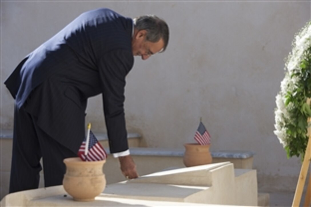 U.S. Defense Secretary Leon E. Panetta places his coin on a U.S. service member’s grave in Tripoli, Libya, Dec. 17, 2011. Panetta visited the western cemetery where U.S. Marines and sailors killed in the 1800s are buried. DOD photo by Erin A. Kirk-Cuomo 