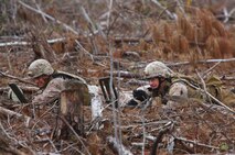 Two technicians with 2nd Explosive Ordnance Disposal Company, 2nd Marine Logistics Group take cover before detonating a simulated explosive during the unit’s training exercise at Camp Davis, N.C., Feb. 12, 2013. The company used the training event as one of several scenarios designed to prepare the unit to support ground operations in Afghanistan. 