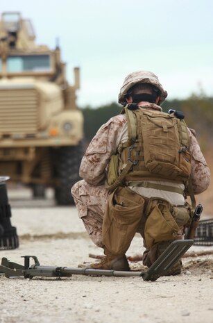A Marine with 2nd Explosive Ordnance Disposal Company, 2nd Marine Logistics Group prepares to clear a road of possible improvised explosive devices during the company’s predeployment training at Camp Davis, N.C., Feb. 12, 2013. The Marine used a metal detector and knife to clear a path onto the road before placing a simulated explosive meant to destroy additional devices on road.