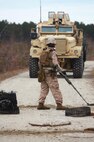 A Marine with 2nd Explosive Ordnance Disposal Company, 2nd Marine Logistics Group sweeps a road with a metal detector during a training exercise at Camp Davis, N.C., Feb. 12, 2013. A team of two Marines worked in unison to clear the area of simulated improvised explosive devices before reopening the road.