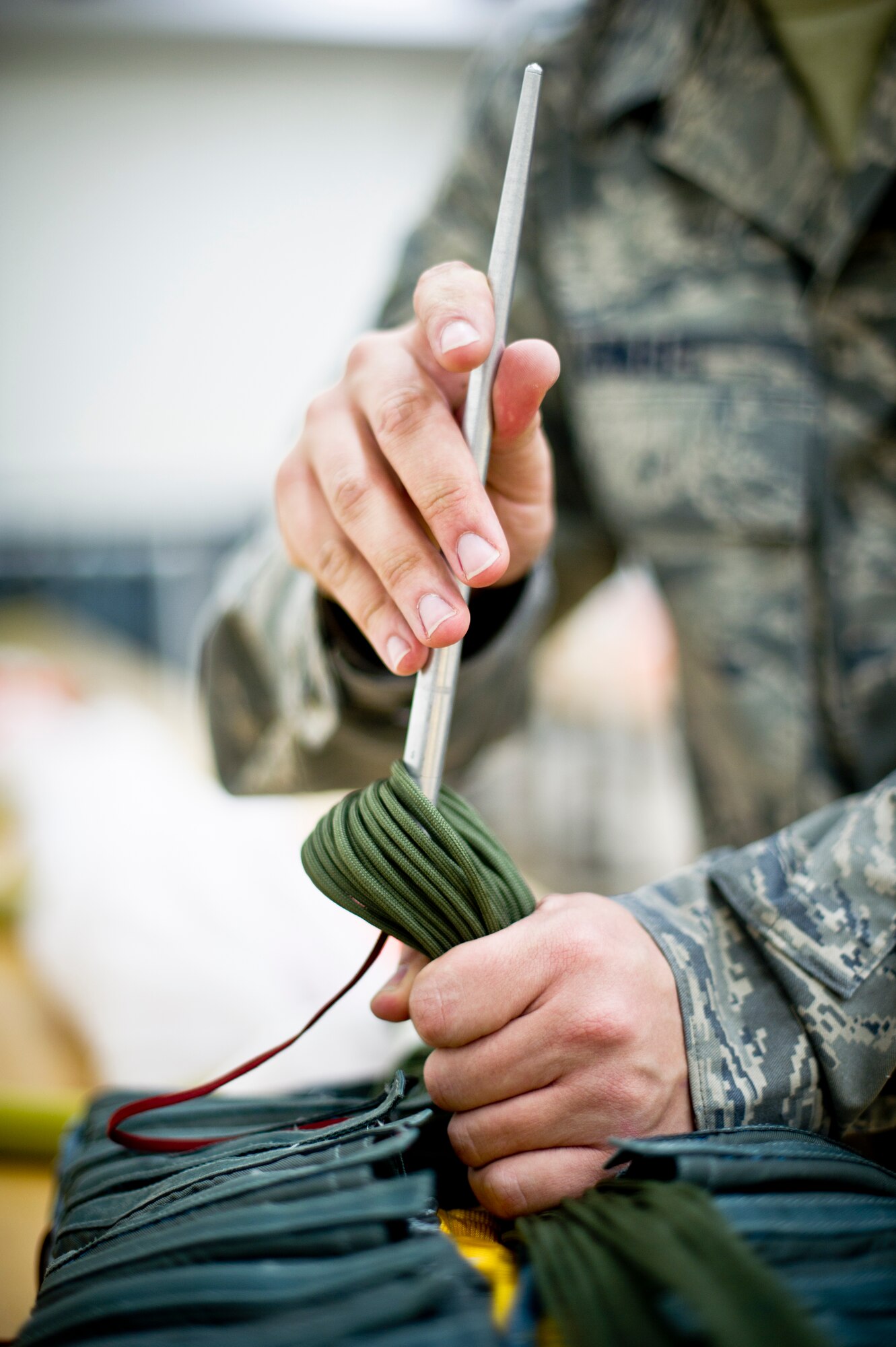 YOKOTA AIR BASE, Japan -- Staff Sgt. Bryan Vrabel, 374th Operations Support Squadron aircrew flight equipment journeyman, packs a parachute after making repairs at Yokota Air Base, Japan, Feb. 14, 2013. Inspecting, repairing and packing a parachute can take up to three hours. (U.S. Air Force photo by Airman Staff Sgt. Stacy Moless)