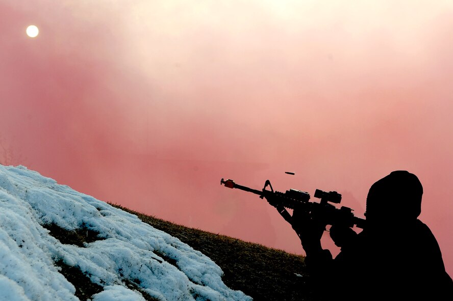 An Airmen acting as opposing forces takes cover and fires at members of the 51st Security Forces Squadron securing the 51st Fighter Wing’s headquarters building during the last simulated ground attack during an operation readiness exercise, Beverly Bulldog 13-02, at Osan Air Base, Republic of Korea, Feb. 15, 2013. These exercises tests Osan Airmen’s abilities during a heightened state of readiness while providing combat ready forces for close air support, air strike control, counter air, interdiction, theater airlift, and communications in the defense of the Republic of Korea. (U.S. Air Force photo/Staff Sgt. Sara Csurilla)