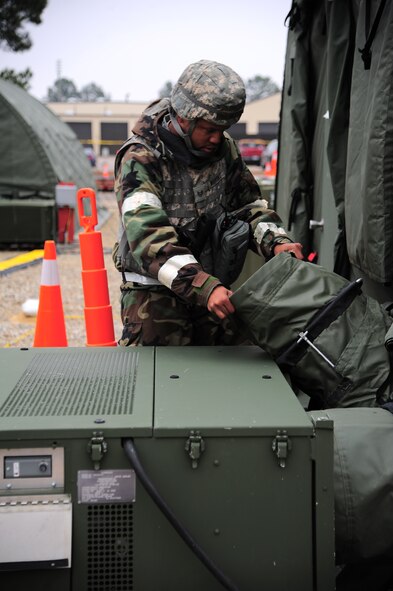 U.S. Air Force Staff Sgt. Charles Martinez, 4th Civil Engineer Squadron heating, ventilation and air conditioning technician, attaches an environment control unit to a tent during Operational Readiness Exercise Coronet Warrior 13-02, at a simulated deployed location on Seymour Johnson Air Force Base, N.C., Feb. 13, 2013. Martinez replaced the unit that was attached to the dining facility to ensure the facility's food maintained proper temperature. (U.S. Air Force photo/Airman 1st Class Aubrey White/Released)
