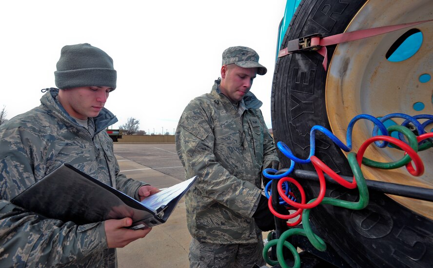 Airman 1st Class Derek Tarter and Senior Airman Jesse Moore, 22nd Logistic Readiness Squadron vehicle operators, review a technical order to make sure that all parts are inspected correctly Feb. 14, 2013, McConnell Air Force Base, Kan. Two checklists are completed before any vehicles are used. (U.S. Air Force photo/Airman 1st Class Colby L. Hardin)