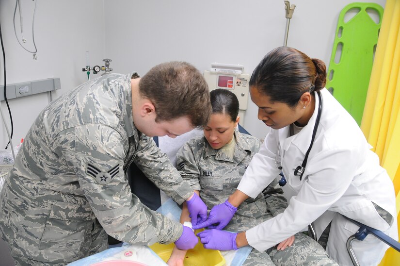 Members of the 579th Medical Group perform an exercise in clinical care Wednesday at their clinic on Joint Base Anacostia-Bolling. Pictured are (Left-Right) Senior Airman Lucas Jensen, medical technician; Senior Airman Kendra Riley, medical technician and Capt. (Dr.) Patricia Evans, family medical physician.  (US Navy Photo by Paul Bello) 
