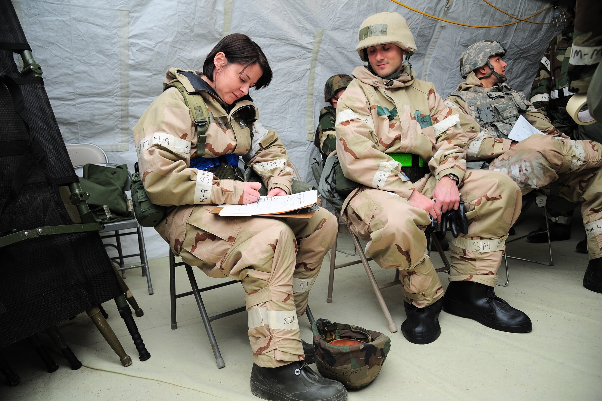 U.S. Air Force Lt. Col. (Dr.) Tara Piech, 4th Medical Operations Squadron family practice physician, makes records of simulated injuries endured by Capt. Joseph Stenger, 335th Fighter Squadron pilot, during a mock attack at a simulated deployed location on Seymour Johnson Air Force Base, N.C., Feb. 13, 2013. Medical personnel diagnose and treat the wounded during fluctuating alarm conditions and mission oriented protective postures. (U.S. Air Force photo/Airman 1st Class Aubrey White/Released)