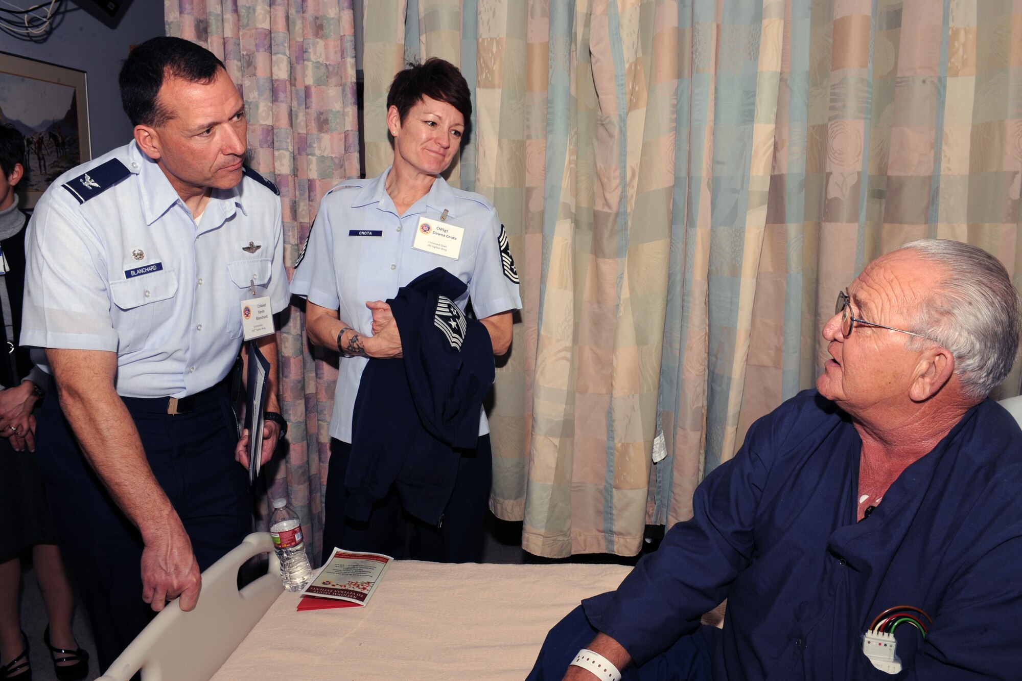U.S. Air Force Col. Kevin Blanchard, 355th Fighter Wing commander and Chief Master Sgt. Dawna Cnota, 355th Fighter Wing command chief master sergeant speak with a military veteran at the VA clinic in Tucson, Ariz., Feb. 12. 2013. Volunteers also handed out thousands of home-made Valentine's Day cards that were sent to the veteran's hospitals from children across the country. (U.S. Air Force photo by Airman 1st Class Christine Griffiths/Released) 
