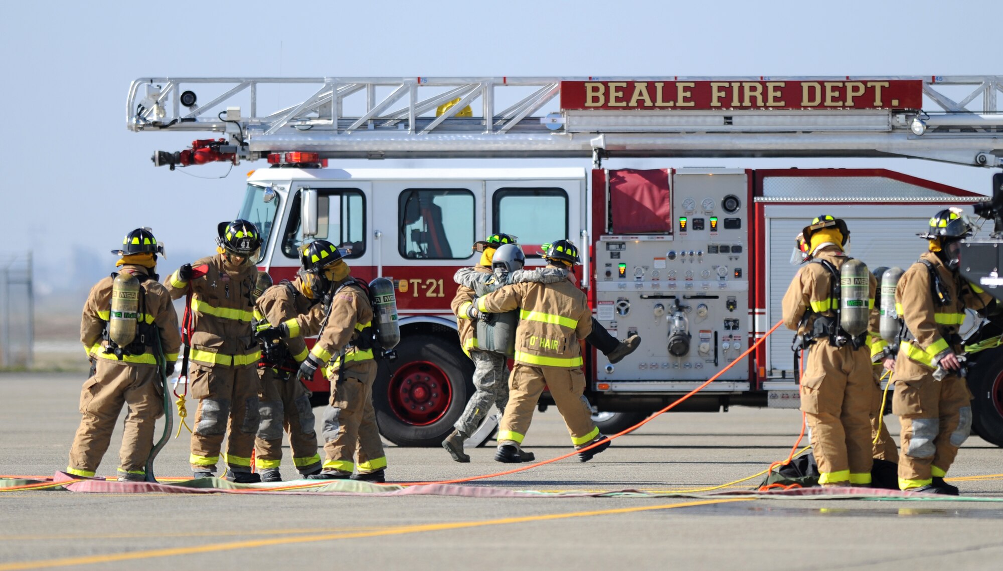 Beale firefighters assist Airman 1st Class Eric Whaley, 9th Civil Engineer Squadron firefighter, to safety during a pilot rescue exercise on the flight-line at Beale Air Force Base, Calif., Feb. 13, 2013. The fire department routinely runs various exercises to stay proficient. (U.S. Air Force photo by Staff Sgt. Robert M. Trujillo/Released)