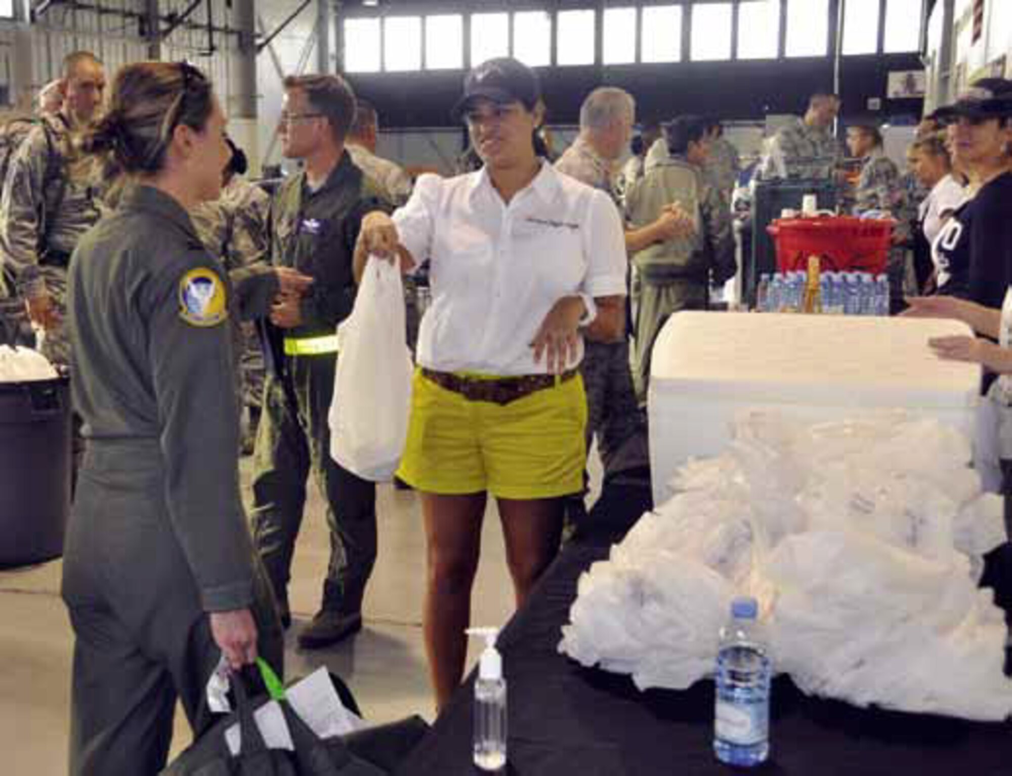 Maj. Jengi Martinez (right), 729th Airlift Squadron and March Aviation Society representative, hands Capt. Robbie Frantal, 729th AS, a free goodie bag of burritos and cookies during the mass in-processing of March members returning from the Operational Readiness Inspection, Feb. 1. (U.S. Air Force photo by Darnell Gardner)