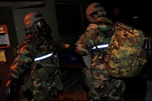 Tech. Sgt. Luis Navarro-Figueroa, right, checks Staff Sgt. Ismael Tabual, 8th Comptroller Squadron, for contaminants during exercise Beverly Bulldog 13-2 at Kunsan Air Base, Republic of Korea, Feb. 14, 2013. The Airmen performed a buddy check to guarantee they were free of chemicals before entering the building. (U.S. Air Force photo by Senior Airman Marcus Morris/Released)