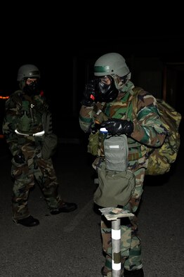Tech. Sgt. Luis Navarro-Figueroa, right, 8th Comptroller Squadron, radios the unit control center the M-8 paper condition during exercise Beverly Bulldog 13-2 at Kunsan Air Base, Republic of Korea, Feb. 14, 2013. PAR teams are used after an attack to check for casualties, unexploded ordnance, contamination from chemical, biological, radiological, nuclear or explosive weapons, and damage to structures and equipment. (U.S. Air Force photo by Senior Airman Marcus Morris/Released)