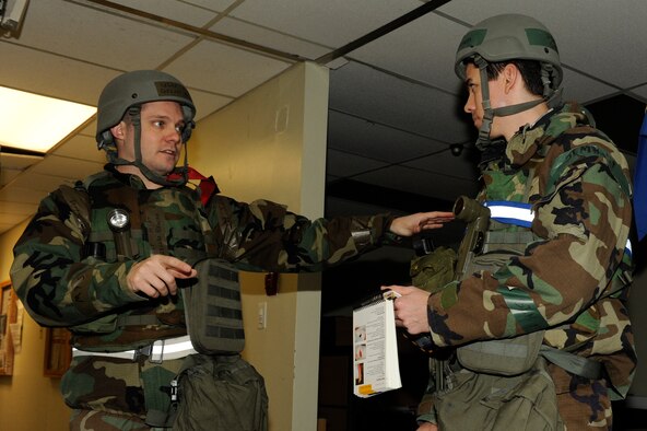 Master Sgt. Gilles Brochu, left, 8th Comptroller Squadron exercise evaluation team, guides 1st Lt. Gregory Brown, 8th CPTS on self-aid and buddy care during exercise Beverly Bulldog 13-2 at Kunsan Air Base, Republic of Korea, Feb. 14, 2013. The team reacted quickly while dealing with a member’s burnt hand. (U.S. Air Force photo by Senior Airman Marcus Morris/Released)