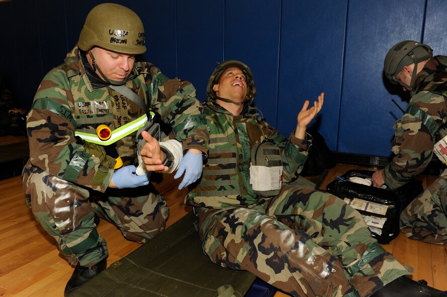 Staff Sgt. Branden Coneita, 8th Medical Operations Squadron noncommissioned officer in charge of immunization clinic, simulates having a broken arm as Capt. Brian Santos, 8th MDOS nurse manager, treats the wound during exercise Beverly Bulldog 13-2 at Kunsan Air Base, Republic of Korea, Feb. 14, 2013. The medical group set up operations in the fitness center after a scenario took out their primary work center. (U.S. Air Force photo by Senior Airman Marcus Morris/Released) 