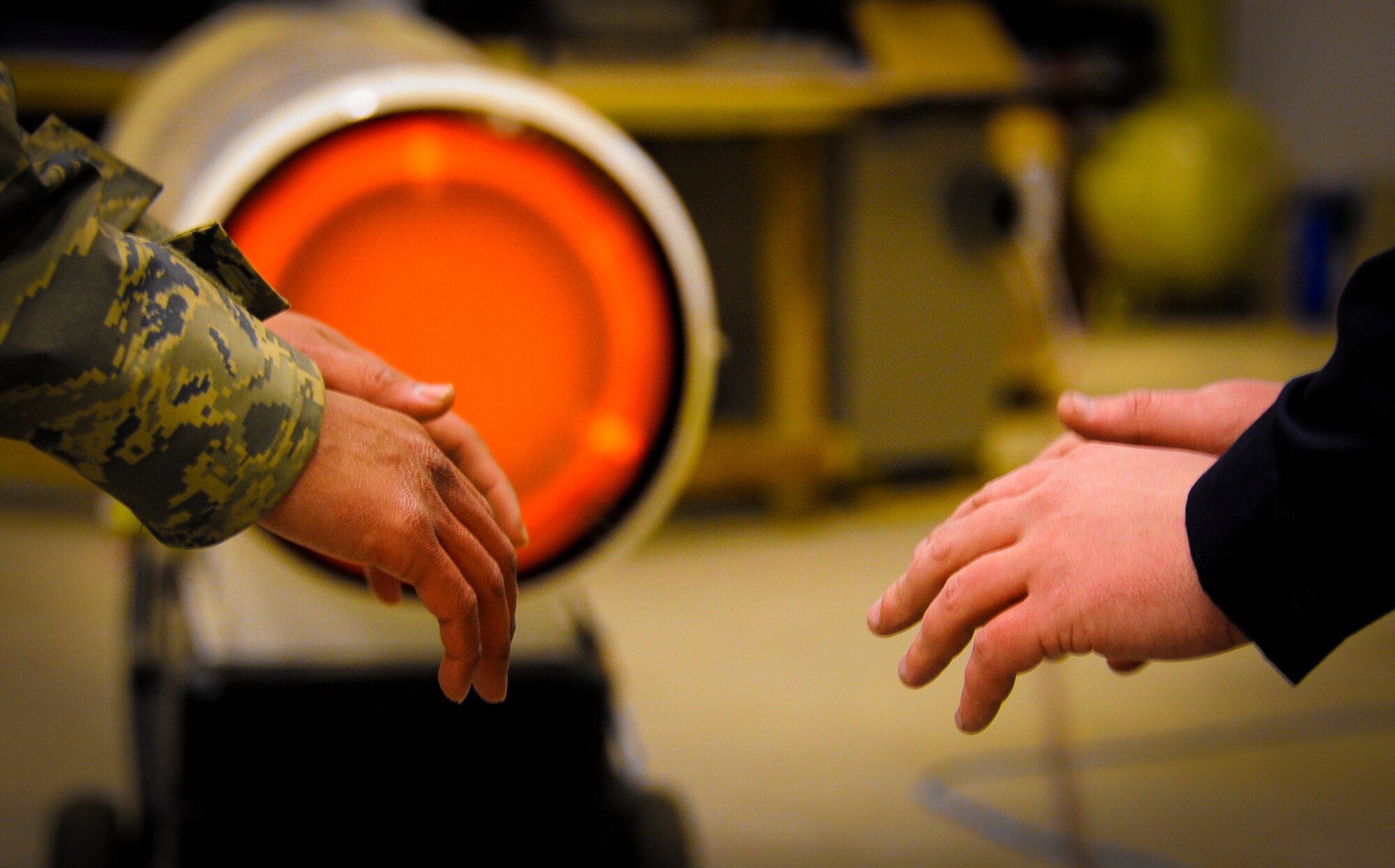 Senior Airman Hiro Dela Cruz and Staff Sgt. Aaron Waldor, 87th Logistics Readiness Squadron vehicle mechanics, warm their hands in front of a bullet heater Feb. 9, 2013, in the Snow Barn at Joint Base McGuire-Dix-Lakehurst, N.J. The 87th LRS, along with other units, worked over the weekend to ensure JB MDL remained mission capable despite the Nor'easter’s snow fall. (U.S. Air Force photo by Airman 1st Class Ryan Throneberry/Released)