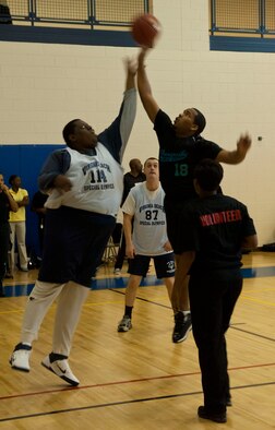 Two Special Olympians battle to tip the jump ball Feb. 9 at Langley Air Force Base, Va., during the Special Olympics basketball tournament. Langley volunteers refereed the event, helping keep score and penalty records. (U.S. Air Force photo by Airman 1st Class Austin Harvill/Released)