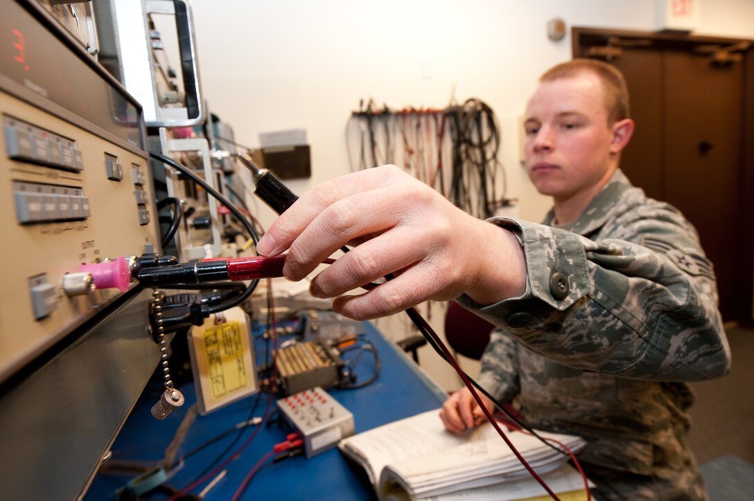 Senior Airman Otis Osborn, 28th Communications Squadron radio frequency transmissions technician, connects an audio analyzer to a portable radio during scheduled maintenance in the 28th CS Radio Maintenance shop on Ellsworth Air Force Base, S.D., Feb. 7, 2013. The audio analyzer provides a test signal modulated through the radio to simulate transmission frequencies over the radio, allowing technicians to accurately locate any malfunctioning areas. (U.S. Air Force photo by Airman 1st Class Kate Thornton-Maurer/Released)