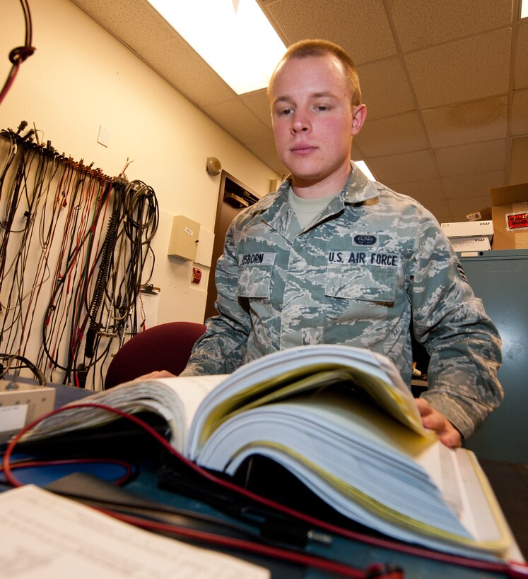 Senior Airman Otis Osborn, 28th Communications Squadron radio frequency transmissions technician, reviews a technical order during maintenance at the 28th CS Radio Maintenance shop on Ellsworth Air Force Base, S.D., Feb. 7, 2013. Airmen are required to utilize TOs during all maintenance procedures to ensure jobs are completed according to established specifications. (U.S. Air Force photo by Airman 1st Class Kate Thornton-Maurer/Released)