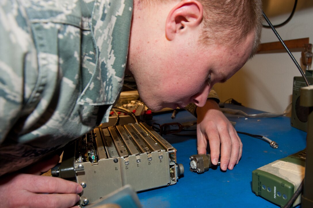 Senior Airman Otis Osborn, 28th Communications Squadron radio frequency transmissions technician, connects a power supply to a portable radio during scheduled maintenance in the 28th CS Radio Maintenance shop on Ellsworth Air Force Base, S.D., Feb. 7, 2013. Connecting the power supply helps technicians pinpoint malfunctions during periodic maintenance. (U.S. Air Force photo by Airman 1st Class Kate Thornton-Maurer/Released)