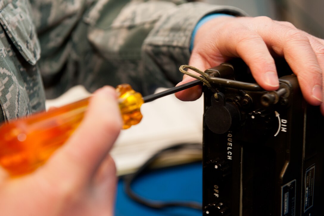 Senior Airman Otis Osborn, 28th Communications Squadron radio frequency transmissions technician, removes a portable radio cover during scheduled maintenance in the 28th CS Radio Maintenance shop on Ellsworth Air Force Base, S.D., Feb. 7, 2013. The cover must be carefully removed to access any malfunctioning components without further damaging the radio. (U.S. Air Force photo by Airman 1st Class Kate Thornton-Maurer/Released)