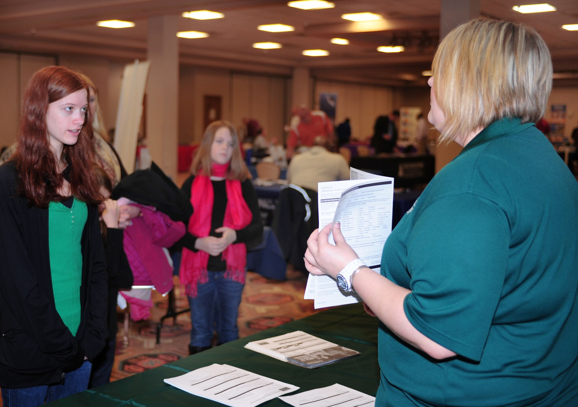 A college representative gives a brochure to an interested attendee at the Education Expo in the Landing Zone, at Cannon Air Force Base, N.M., Feb. 12, 2013. The expo included more than 20 schools and was designed to introduce college education options to military members and their families. (U.S. Air Force photo/Airman 1st Class Ericka Engblom)