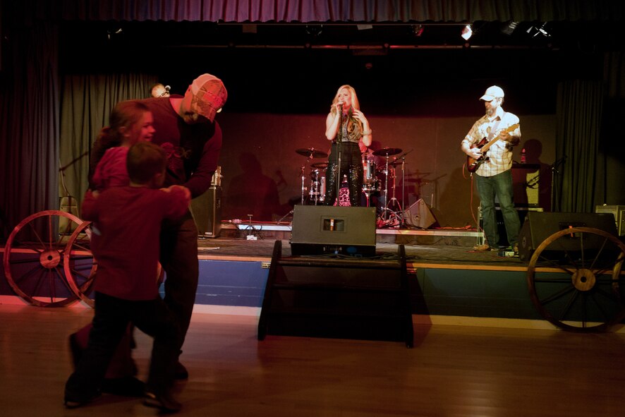 RAF ALCONBURY, United Kingdom – Master Sgt. Rocky Casto, 423rd Air Base Group first sergeant, two-steps with his children on the dance floor at the RAF Alconbury Community Activities Center during a free concert by country and western singer Ali Dee Feb. 12. Dee also performed a free concert at RAF Croughton Feb. 11. (U.S. Air Force photo by Staff Sgt. Brian Stives)