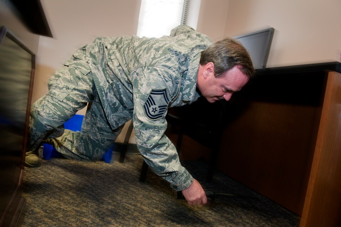 GRISSOM AIR RESERVE BASE, Ind. -- Senior Master Sgt. Joseph Lageose, 434th Maintenance Squadron production superintendent, dives under a desk during an earthquake exercise here Feb. 7. During an earthquake, it is recommended people follow the steps of drop, get under cover and hold on to protect themselves from falling debris. (U.S. Air Force photo illustration/Tech. Sgt. Mark R. W. Orders-Woempner)
