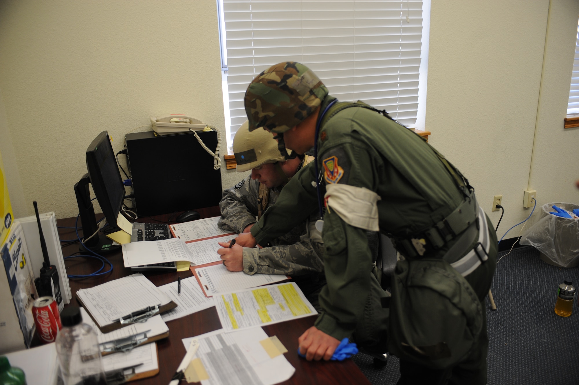 U.S. Air Force Maj. Kevin Loh, 366th Medical Group flight surgeon and Staff Sgt. Michael Montgomery, 366th MDG medic, coordinate a medical evacuation for patients inside the treatment facility Feb. 13, 2013, at Mountain Home Air Force Base, Idaho. Paperwork is extremely important and must be filled out correctly in order to ensure mission success and patient safety. (U.S. Air Force photo/Senior Airman Benjamin Sutton)