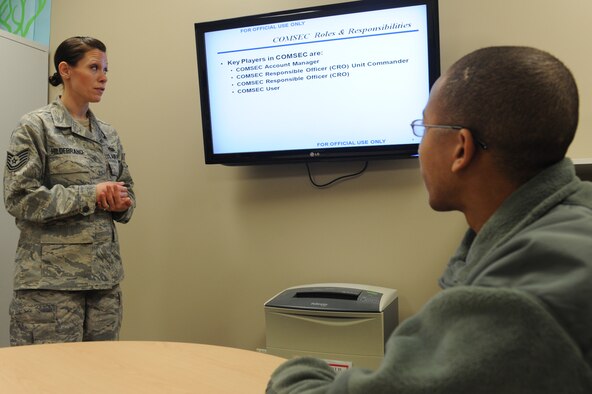 WHITEMAN AIR FORCE BASE, Mo. -- Tech. Sgt. Jessica Hildebrand, 509th Communications Squadron Wing Information Assurance Office NCOIC, reviews training slides with Airman 1st Class Orville Butler, 509th CS WIO, Feb. 11. Every time the B-2 takes off, the WIAO manages 10 different COMSEC items which guarantee the protection of each mission. (U.S. Air Force photo/Airman 1st Class Bryan Crane)