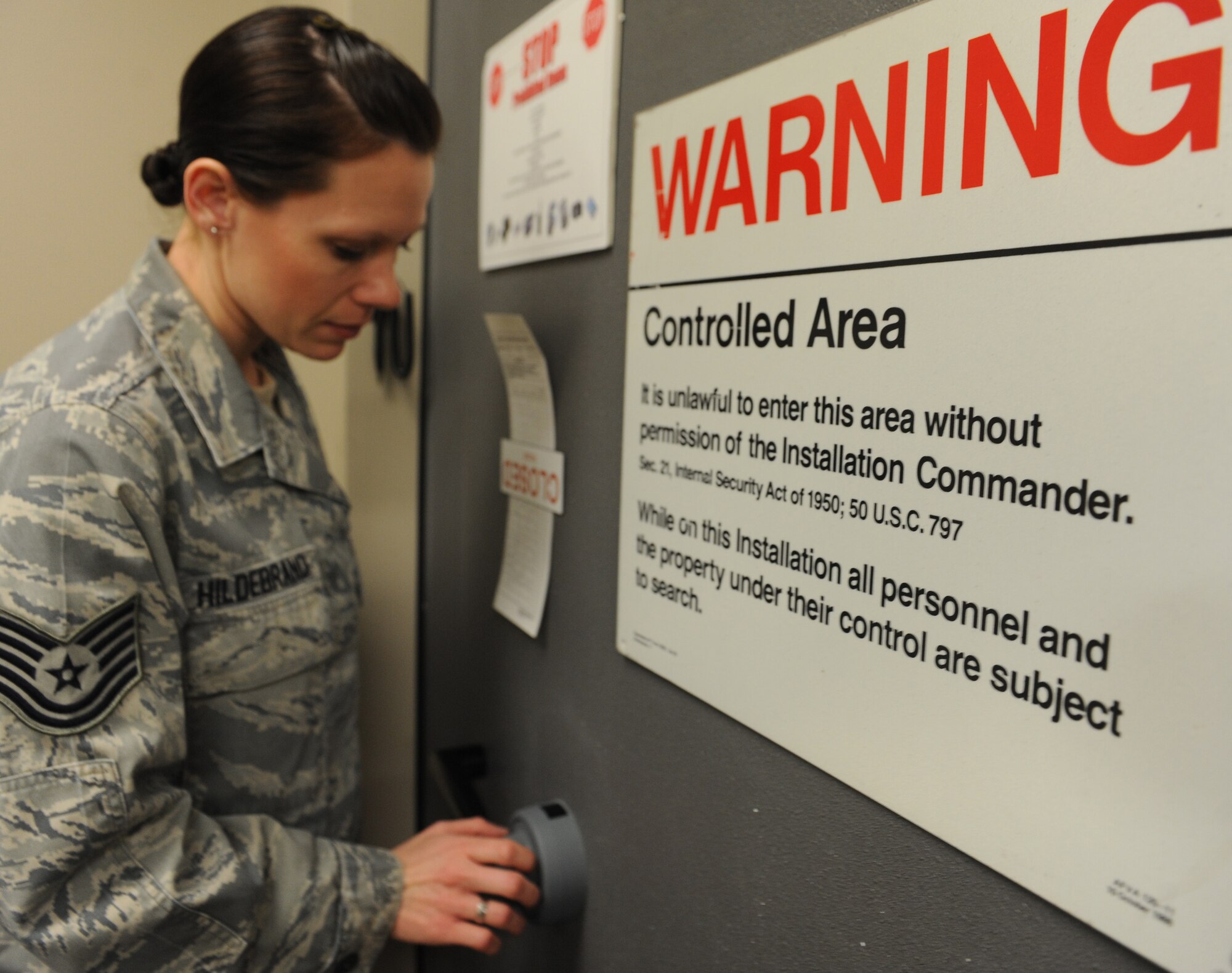 WHITEMAN AIR FORCE BASE, Mo. -- Tech. Sgt Jessica Hildebrand, 509th Communications Squadron Wing Information Assurance Office NCOIC, opens the COMSEC vault door, Feb. 11.  The WIAO shop is a workcenter with five first-term Airmen and only one NCOIC. (U.S. Air Force photo/Airman 1st Class Bryan Crane)