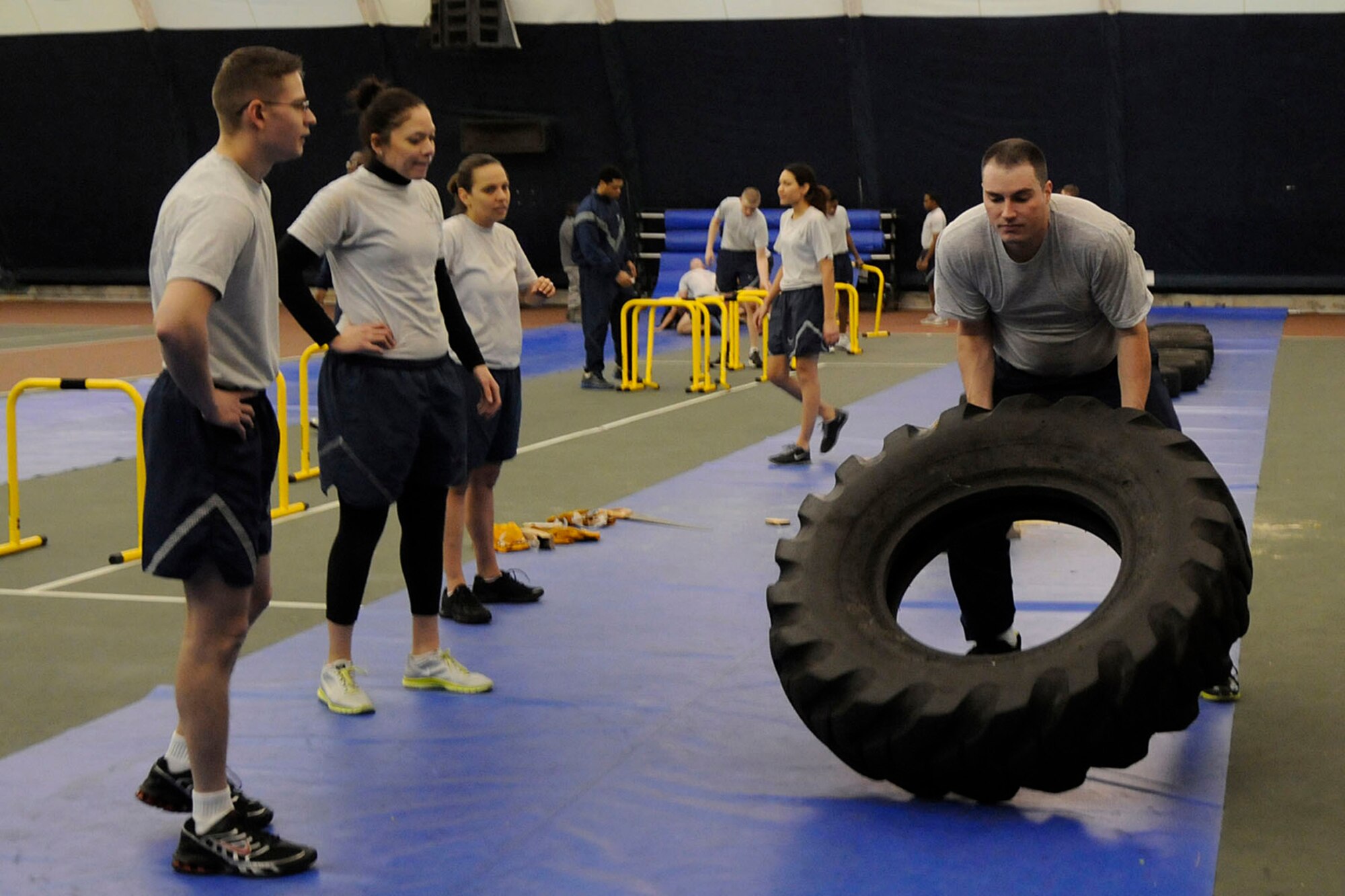 HANSCOM AIR FORCE BASE, Mass. -- Staff Sgt. Kyle Hoffman, 66th Comptroller Squadron accounting technician, moves a tire as other members of the 66th Air Base Group participate in the group's monthly Warrior Day morning workout in the Tennis Bubble Feb. 6. This month, eight teams participated in nine obstacles over the course of about 45 minutes. (U.S. Air Force photo by Linda LaBonte Britt)