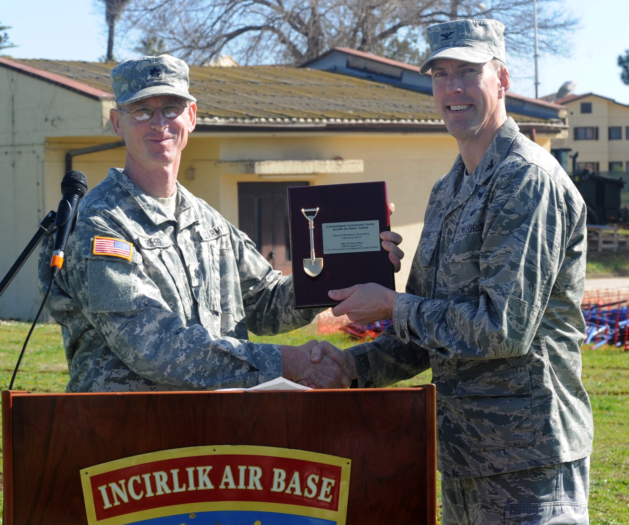 Col. Chris Craige, 39th Air Base Wing commander, receives a plaque from Lt. Col. Rick Rieger, United States Army Corps of Engineers Europe District Air Force program manager, during the groundbreaking ceremony for the Consolidated Community Center Feb. 13, 2013 at Incirlik Air Base, Turkey. The plaque represents a token of partnership and trust for the Army Corps of Engineers to build the new facility. (U.S. Air Force photo by Staff Sgt. Eric Summers Jr. / Released)