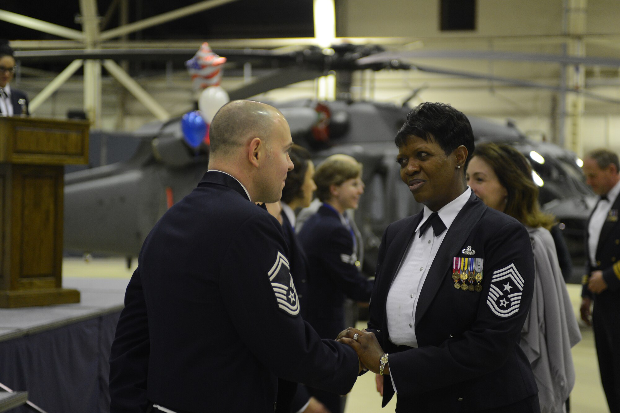 ROYAL AIR FORCE LAKENHEATH, England -- Chief Master Sgt. SaRita Lathan, 48th Fighter Wing command chief, presents Senior Master Sgt. Lee Ayers, 48th Logistics Readiness Squadron material management flight chief and Senior NCO of the Year award winner, with a coin at the 48th FW Annual Awards Banquet at Hangar 7 Feb. 9, 2013.  Following the awards ceremony, the annual award winners were congratulated by base leadership, Liberty Wing Airmen and family members. (U.S. Air Force photo by Airman 1st Class Dana J. Butler)