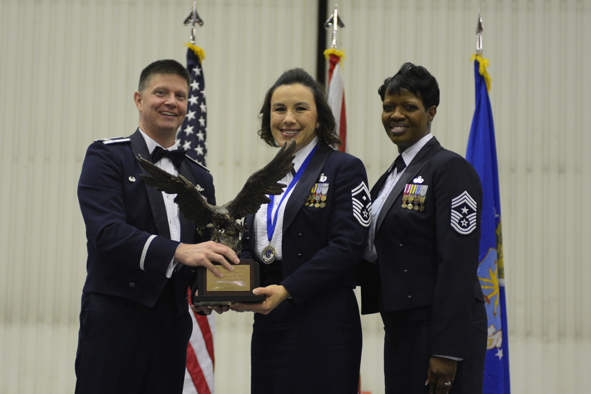 ROYAL AIR FORCE LAKENHEATH, England -- Col. Kyle Robinson, 48th Fighter Wing commander and Chief Master Sgt. SaRita Lathan, 48th Fighter Wing command chief, present Senior Master Sgt. Yuvonne Fischer, 48th Aircraft Maintenance Squadron first sergeant, with the First Sergeant of the Year Award during the 48th FW Annual Awards Banquet at Hangar 7 Feb. 9, 2013. (U.S. Air Force photo by Airman 1st Class Dana J. Butler)