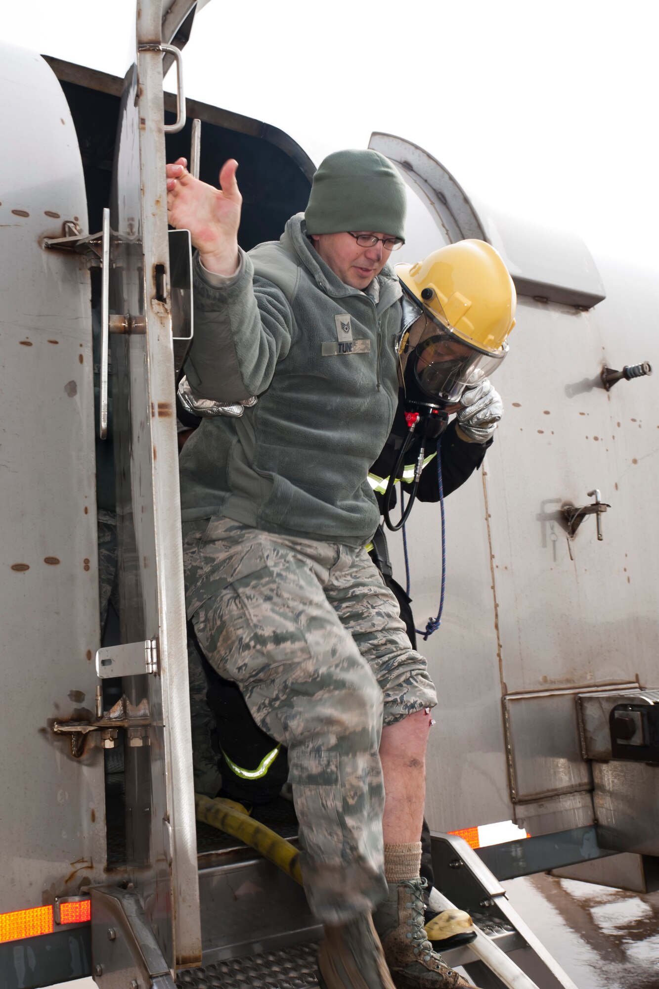 Staff Sgt. Bryan Tune, 8th Aircraft Maintenance Squadron, is assisted off the aircraft by a Republic of Korea air force firefighter after sustaining shrapnel in his left leg during a simulated aircraft incident during exercise Beverly Bulldog 13-2 at Kunsan Air Base, Republic of Korea, Feb. 14, 2013. Tune and four other Airmen were trapped in the downed aircraft until the fire department rescued them. (U.S. Air Force photo by Tech. Sgt. Michael Schocker/Released)