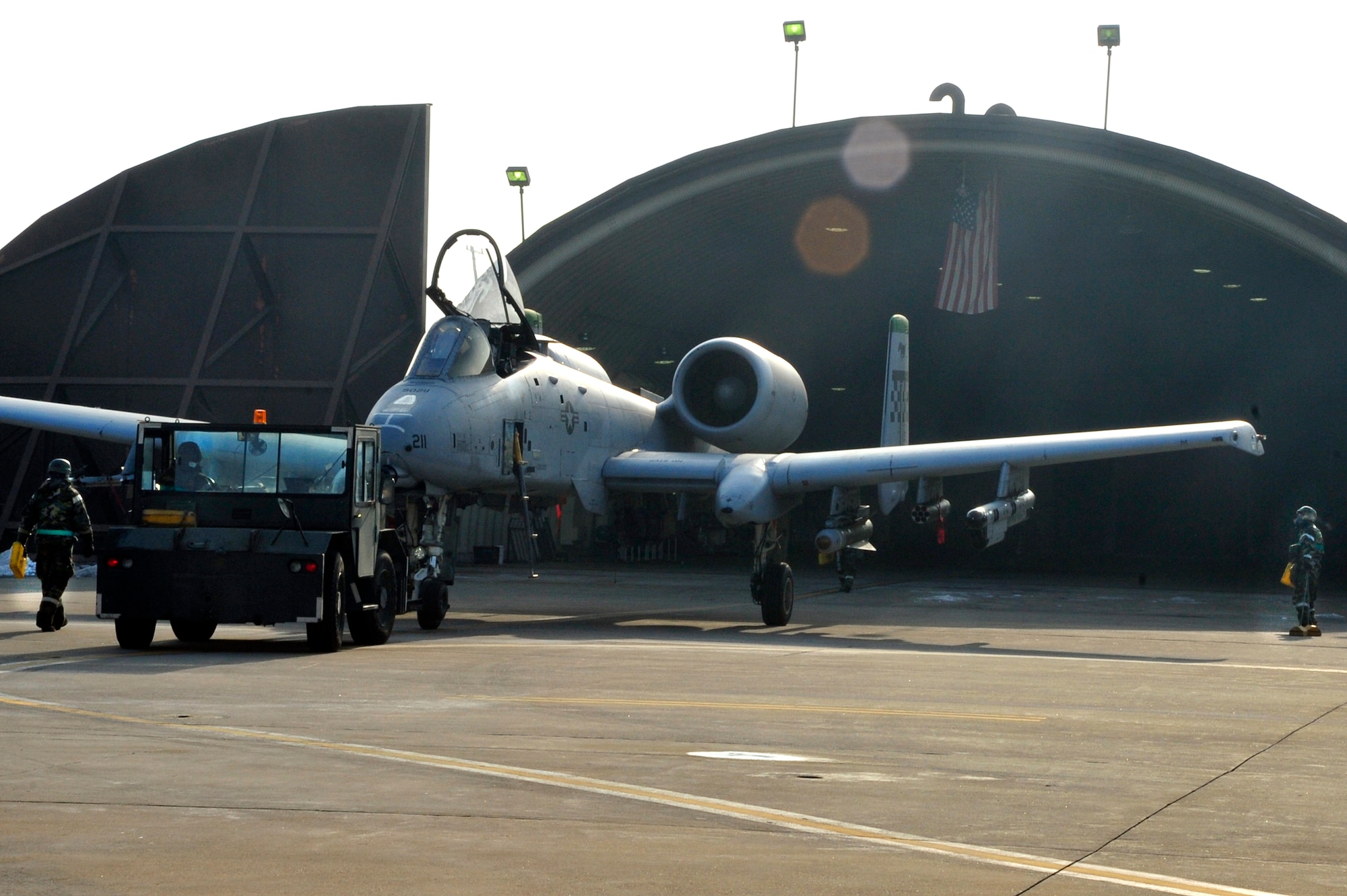 Maintainers with the 51st Maintenance Squadron wearing Mission Oriented Protective Posture gear toe an A-10 Thunderbolt II into a hangar following an exercise combat sortie during operational readiness exercise, Beverly Bulldog 13-02, at Osan Air Base, Republic of Korea, Feb. 14, 2013. These exercises test Osan Airmen’s abilities during a heightened state of readiness while providing combat ready forces for close air support, air strike control, counter air, interdiction, theater airlift and communications in defense of the Republic of Korea. (U.S. Air Force photo/Airman 1st Class Alexis Siekert)