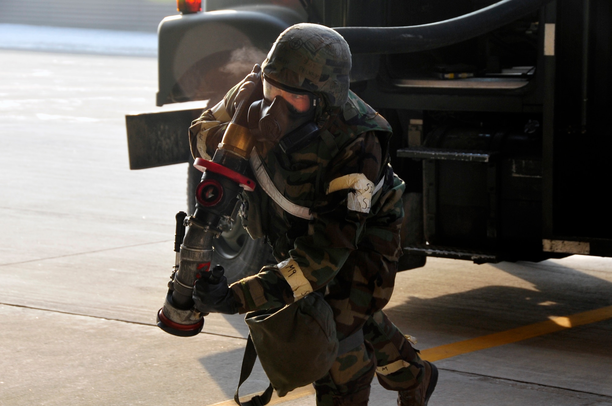 Staff Sgt. Joseph Pelkey, 51st Logistics Readiness Squadron Petroleum, Oil and Lubricants fuels distribution operator, runs a gas line to an aircraft after it landed from an exercise sortie at Osan Air Base, Republic of Korea, Feb. 14, 2013. Airmen don Mission Oriented Protective Posture gear in wartime following an attack when contamination is present or suspected or when the highest level of protection is required. (U.S. Air Force photo/Airman 1st Class Alexis Siekert)
