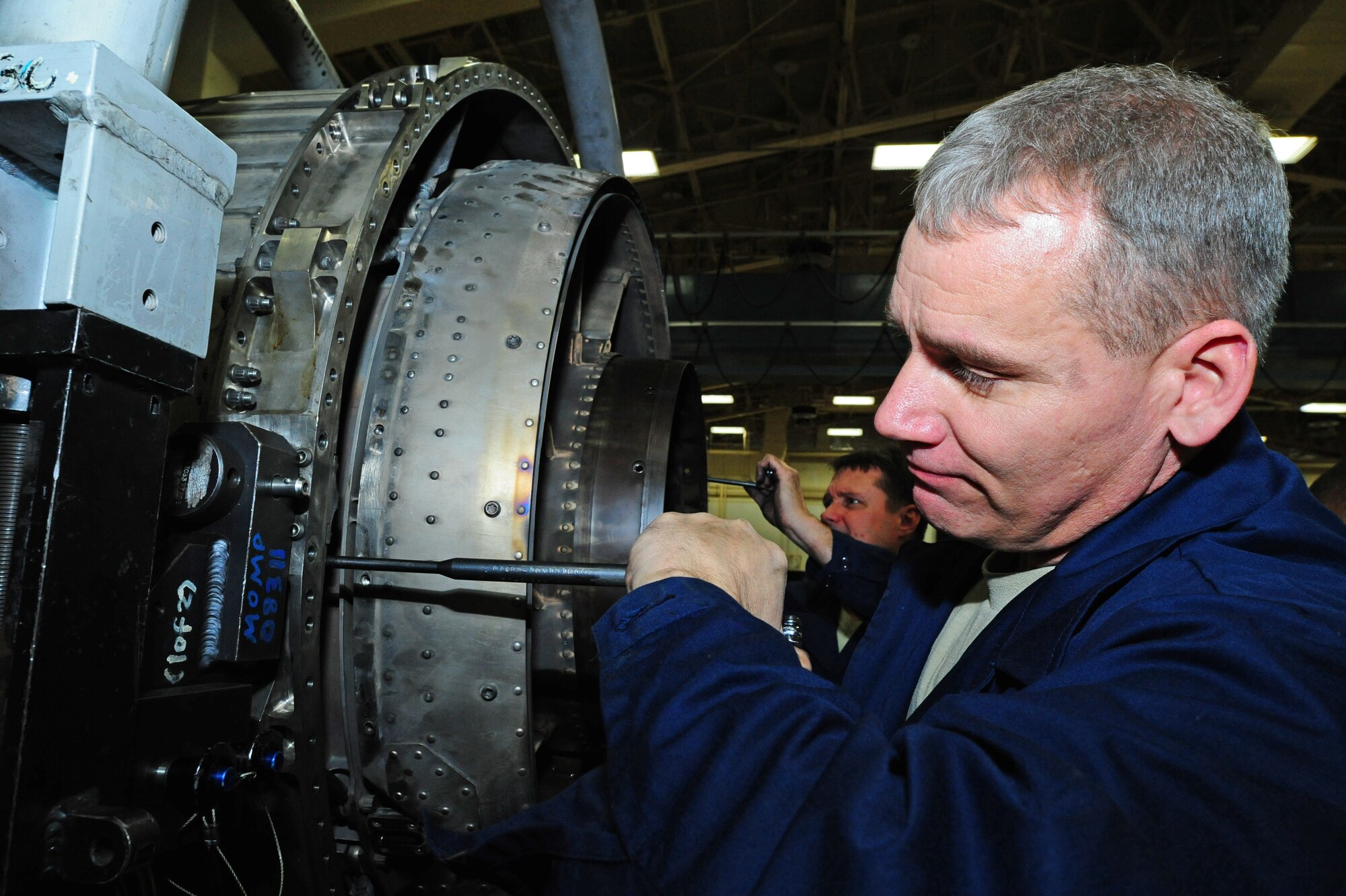 U.S. Air Force Chief Master Sgt. James Laurent (front), 35th Fighter Wing command chief, and Col. Matthew Dana, 35th Fighter Wing vice commander, work together to remove more than 40 fairings from the major assembly low pressure turbine during the Dirty Jobs Program on Misawa Air Base, Japan, Feb. 13, 2013.  The Dirty Jobs Program was designed to give Airmen of multiple squadrons the opportunity share their dedication to their job and technical experiences with wing leadership.  (U.S. Air Force photo by Staff Sgt. April Quintanilla)