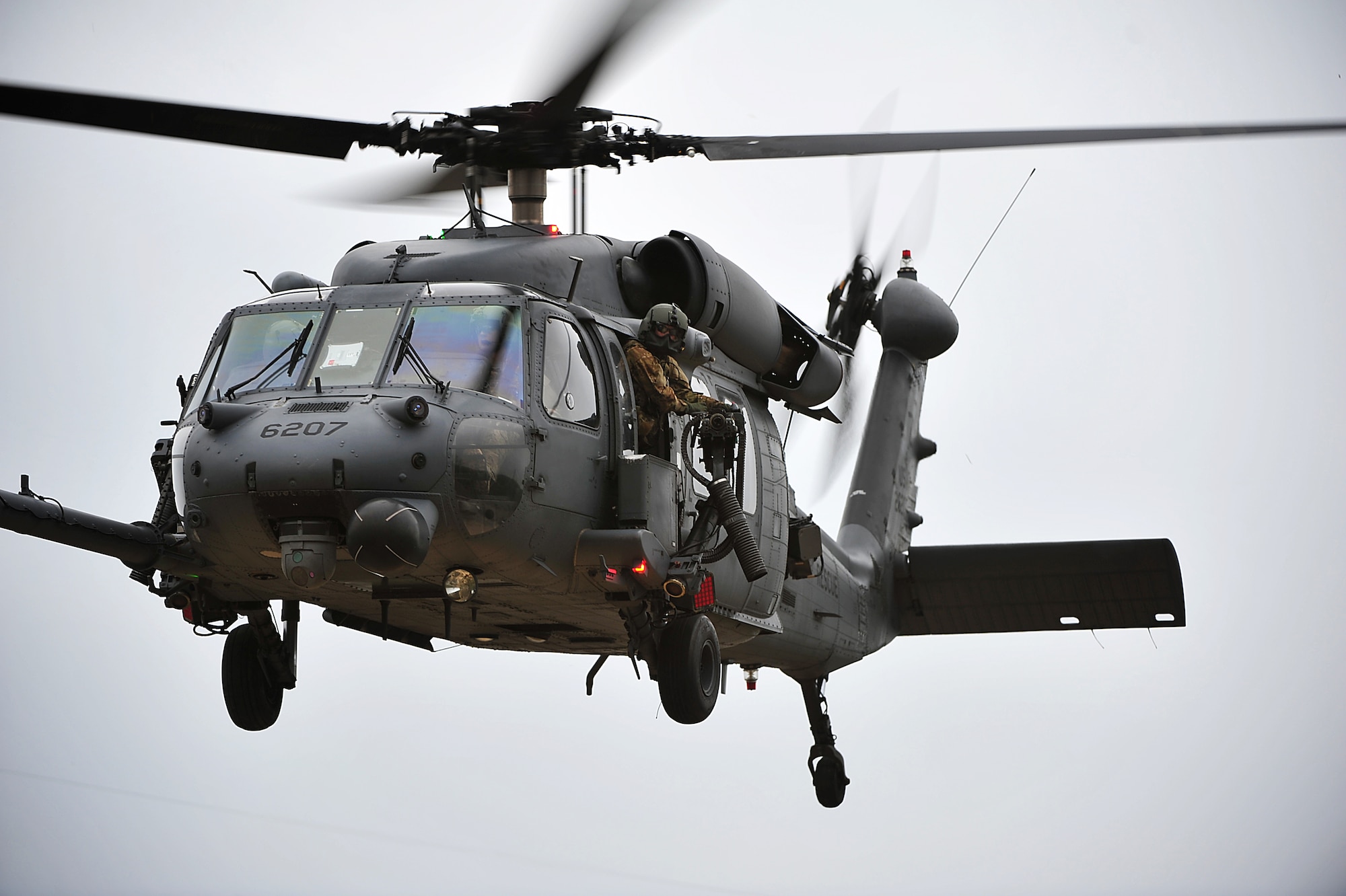 A U.S. Air Force aerial gunner for an HH-60 Pave Hawk helicopter from the 33rd Rescue Squadron surveys the area for potential threats during a war week exercise at Marine Corps Camp Hansen's Combat Town, Japan, Feb. 6, 2013. War week, a three-day pre-deployment exercise, gave members from both of Kadena Air Base's rescue squadrons the opportunity to practice numerous rescue scenarios in a controlled environment. (U.S. Air Force photo/Senior Airman Maeson L. Elleman)