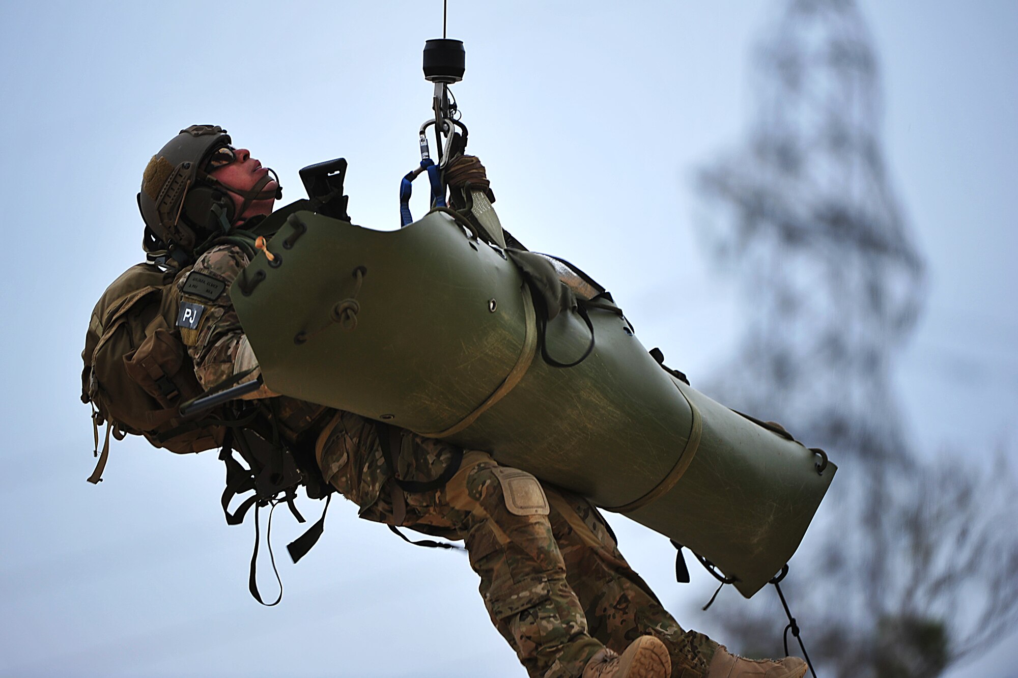U.S. Air Force Staff Sgt. Elmer Quijada, 123rd Special Tactics Squadron pararescueman, is hoisted into a 33rd Rescue Squadron HH-60 Pave Hawk helicopter along with a simulated casualty during a war week exercise at Marine Corps Camp Hansen's Combat Town, Japan, Feb. 7, 2013. During the exercise, members from the 31st and 33rd RQSs practiced a multitude of scenarios, including extraction under fire, convoy attacks and aircraft incidents. (U.S. Air Force photo/Senior Airman Maeson L. Elleman)